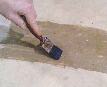 Brushing epoxy seal coat clear onto concrete.