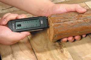 Damp Meter in use testing a piece of wood